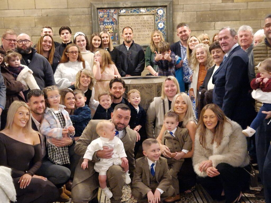 a group of people surrounding a church font